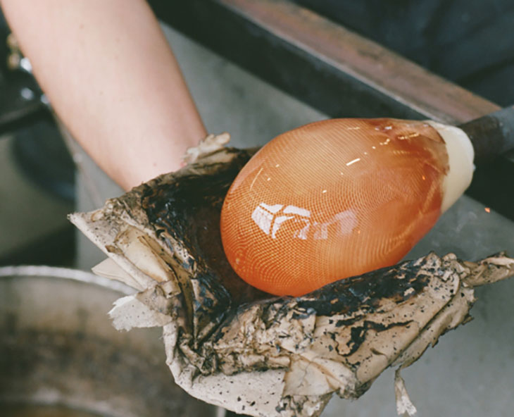 glass blower making glass orb of an 84 series lighting design by bocci