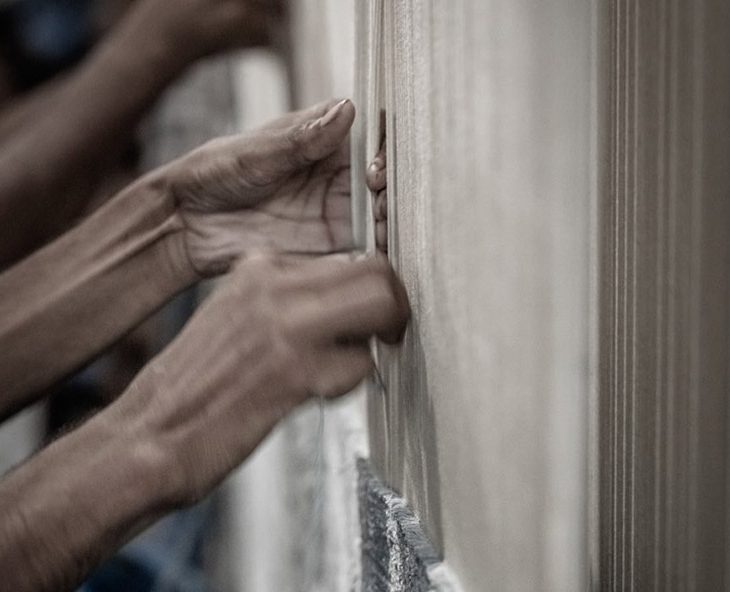 rugmakers knotting a kymo rug