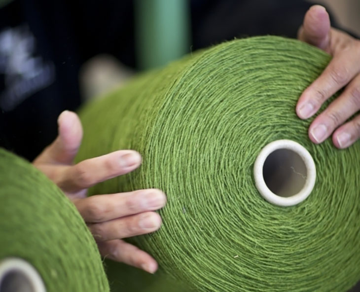 giant spools of green wool yarn at the kasthall rug factory