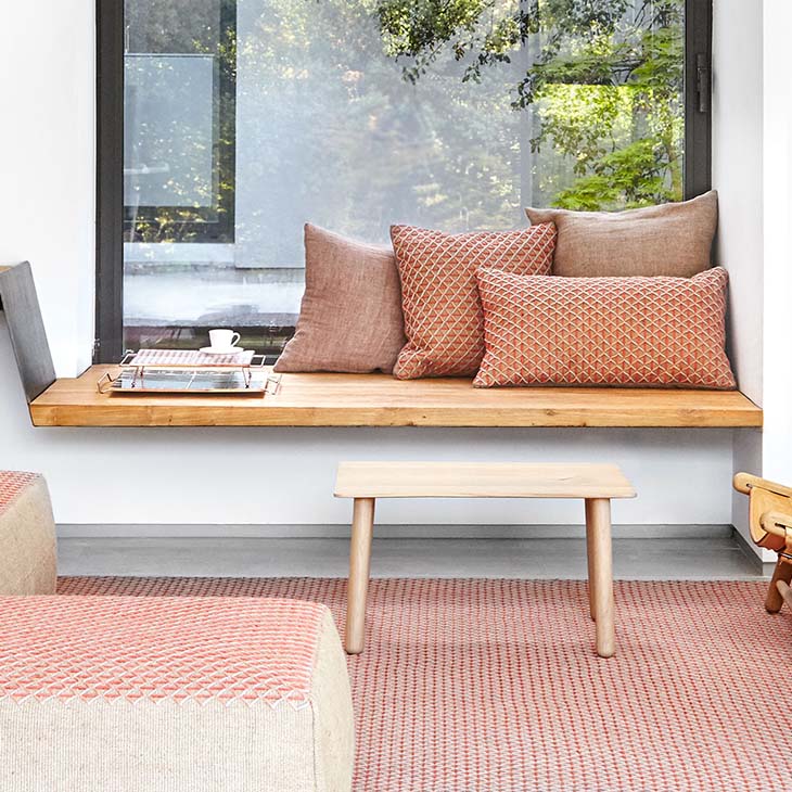 gan raw spaces rug, poufs, and pillows in a cozy room