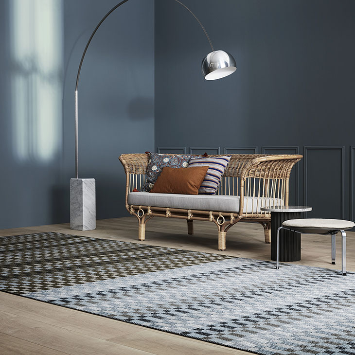 rattan sofa near a kasthall poetry rug