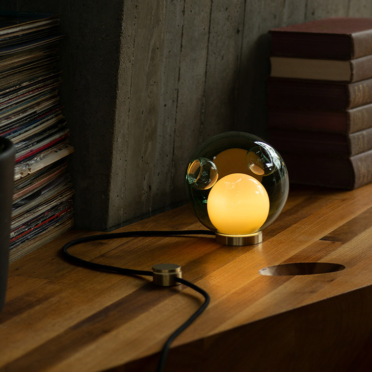 interior space featuring bocci 28t table lamp on wood shelf