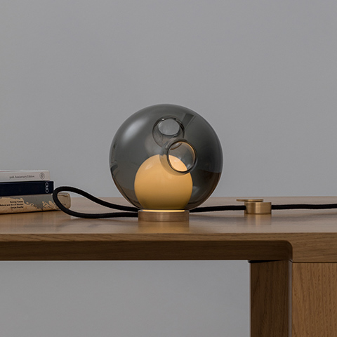interior space featuring bocci 28t table lamp on wood desk