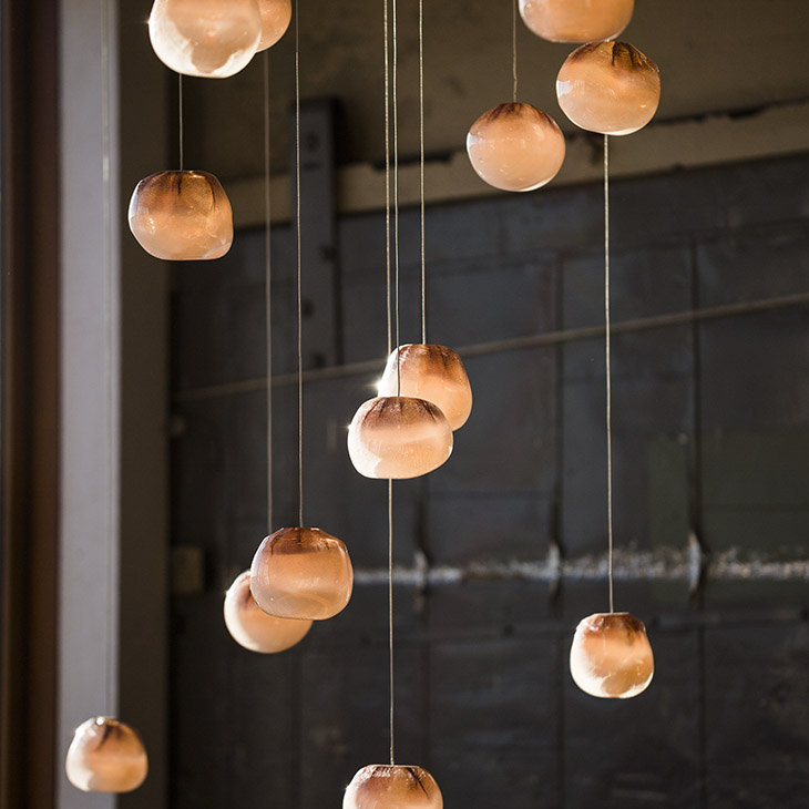 close up of bocci 84 series pendant light glowing in a warehouse space