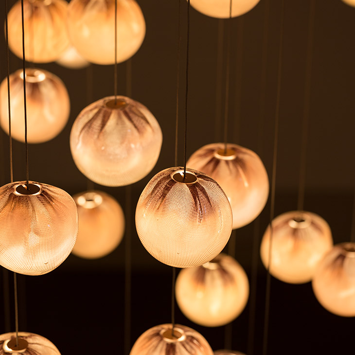 close up of bocci 84 series pendant light glowing in a dark room