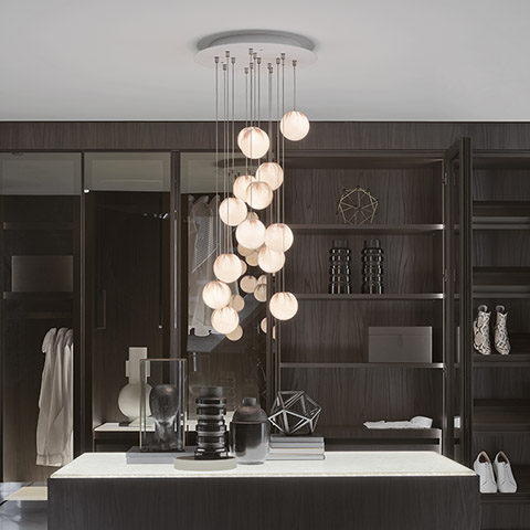 modern walk-in closet featuring bocci 84 pendant light