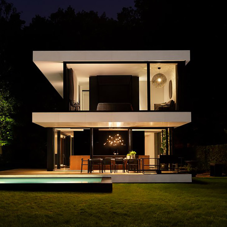 exterior of a modern house featuring a moooi flock of light pendant glowing in the first floor window