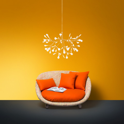 moooi heracleum II suspended pendant light hanging above an armchair