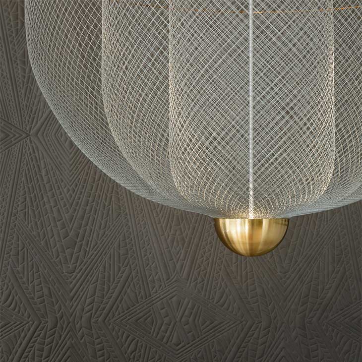 close up of a moooi meshamatics pendant light against a grey wallpapered wall