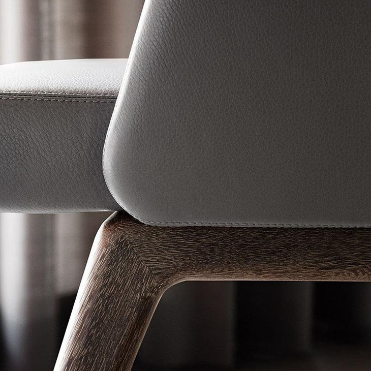 close up of leather upholstery and sucupira legs on a minotti reeves dining chairs
